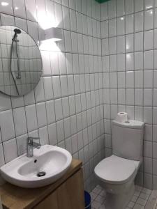 a bathroom with a toilet and a sink and a mirror at Skylight 1BR Apartment Mar Mikhael in Beirut