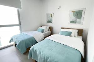 A bed or beds in a room at Amchit Bay Beach Residences 2BR Rooftop