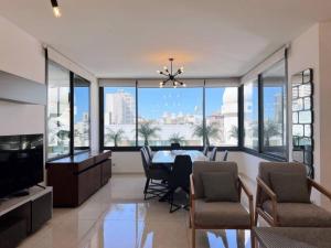 a dining room with a table and chairs and windows at Elevated 2BR living in Hamra in Beirut