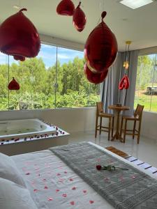 a bedroom with a bed with red chandeliers above it at Sítio Barriguda in Alexânia