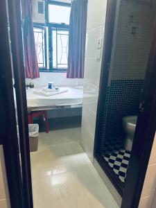 a bathroom with a shower with a toilet and a sink at KATHMANDU GUEST HOUSE in Hong Kong