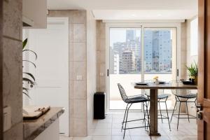 a kitchen with a table and chairs and a large window at Stunning Artist House in Saifi in Beirut