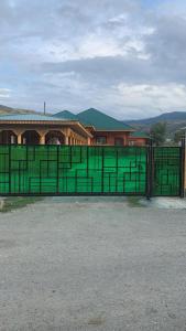 a green metal gate in front of a building at Kolsay Aisha in Saty
