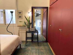 a bedroom with a red door and a table with a plant at Designer 1BR apt in Gemmayze in Beirut