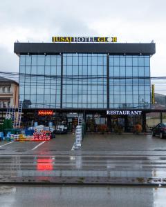 a building with a lot of windows in a parking lot at Jusaj Hotel Glob in Peje