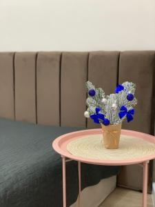 a table with a vase with blue flowers on it at Comfort Home Soborna 283 in Rivne