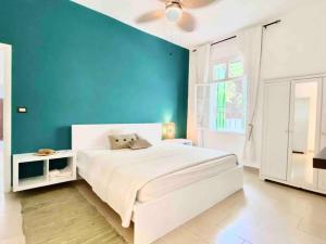 1 dormitorio con cama blanca y pared azul en 3BR on MM stairs with a quiet terrace, en Beirut