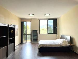 1 dormitorio con 1 cama y algunas ventanas en Pleasant 1BR apt with green views - Jamhour, en Rujūm