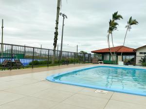 a swimming pool at a resort with palm trees at Residencial Privilegio in Florianópolis