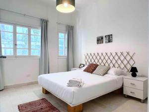 Un dormitorio con una gran cama blanca y una ventana en Sunlit 2BR apt on MarMikhael Stairs, en Ar Rumayl