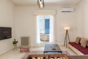 Mauds Elegant Cocoon at Monot في بيروت: غرفة معيشة مع أريكة حمراء ونافذة