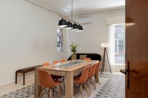 a dining room with a wooden table and orange chairs at Mauds Elegant Cocoon at Monot in Beirut