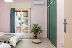 a bedroom with two beds and a potted plant at Mauds Elegant Cocoon at Monot in Beirut