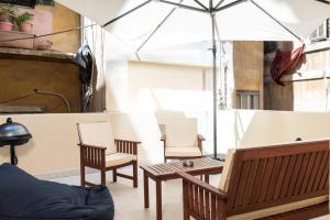 Mauds Elegant Cocoon at Monot في بيروت: غرفة معيشة مع كرسيين ومظلة