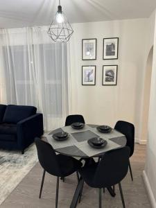 uma mesa de jantar com cadeiras e um sofá azul em Modern apartment, 1km from city! em Elswick