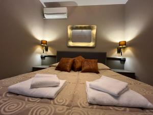 een slaapkamer met een bed met 2 kussens en een spiegel bij Hotel Roma in Palmanova