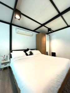 a bedroom with a large white bed in a room at Peaceful & Contemporary Duplex Escape in Ban Thap Nang