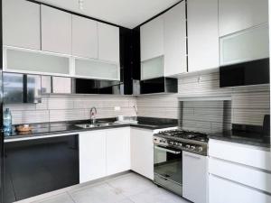 ベイルートにあるModern 3BR Apt next to Hotel Dieuのキッチン(白いキャビネット、シンク、コンロ付) +10枚の写真