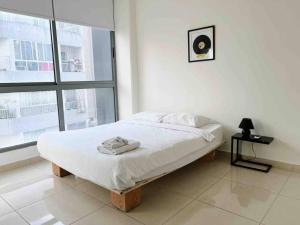 a white bedroom with a bed and a window at Modern 3BR Apt next to Hotel Dieu in Beirut