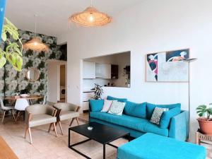 uma sala de estar com um sofá azul e uma mesa em Bright Loft 4BR MarMikhael em Beirute