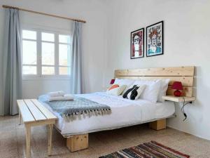 a bedroom with a bed with a bench and a window at Bright Loft 4BR MarMikhael in Beirut