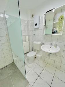 ein weißes Bad mit einem WC und einem Waschbecken in der Unterkunft Dortmund City Wohnung 85/7 in Dortmund