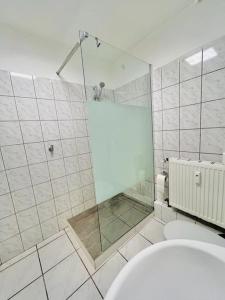 a white bathroom with a shower and a toilet at Dortmund City Wohnung 85/7 in Dortmund