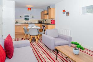 a living room with a table and chairs and a kitchen at Cosy Two Bedroom Apartment in Crewe, Free Parking in Crewe