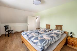 ein Schlafzimmer mit einem großen Bett und einem Stuhl in der Unterkunft Ferienwohnung Am Süßen See in Seeburg