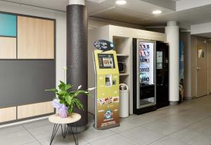 a vending machine in a lobby with a drink machine at B&B HOTEL Paris Nord Villepinte in Villepinte