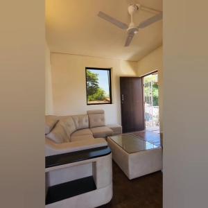 - un salon avec un canapé et un ventilateur de plafond dans l'établissement D'Ecke, à Taleigao