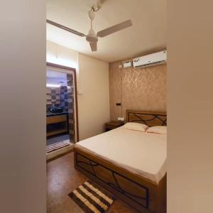 1 dormitorio con 1 cama y ventilador de techo en D'Ecke, en Taleigao
