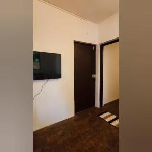 um quarto com uma televisão de ecrã plano na parede em D'Ecke em Taleigao