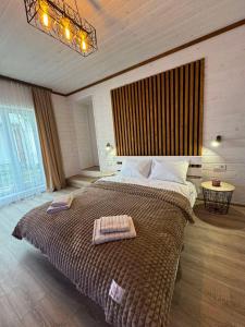 a bedroom with a large bed with two towels on it at Welcom Verkhovyna in Verkhovyna +46 photos