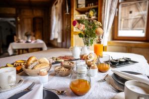 a table with a breakfast of food and orange juice at Pardellerhof Lüsen Doppelzimmer Nussbaum in Luson
