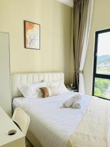 a bedroom with a large white bed with a window at The Horizon Ipoh By Iconique Espace in Ipoh