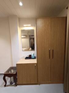 a bathroom with a wooden cabinet and a mirror at Hotel Monsoon Palace Guwahati in Guwahati