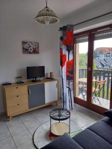 un salon avec un canapé et une télévision dans l'établissement Appartement 50 m de la mer proche Deauville, à Villers-sur-Mer