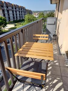 une table et des chaises en bois sur un balcon dans l'établissement Appartement 50 m de la mer proche Deauville, à Villers-sur-Mer 2 autres photos