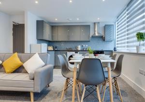 eine Küche und ein Wohnzimmer mit einem Sofa und einem Tisch in der Unterkunft Raglan Apts-central Location, Freeparking in Scarborough