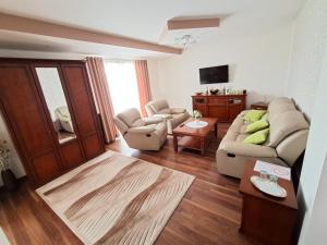 a living room with two couches and a television at Penzión Stavbet in Svidník