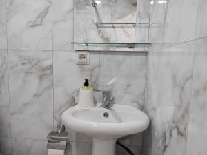 Baño blanco con lavabo y espejo en Sun House, en Yeghegnadzor