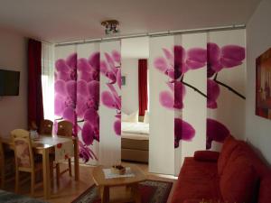 una sala de estar con flores púrpuras en la pared en Apartment Mengelberg, en Markkleeberg