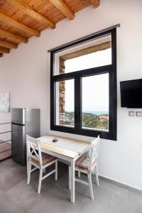 a dining room with a table and chairs and a window at Monopati Eco Villas in Raches