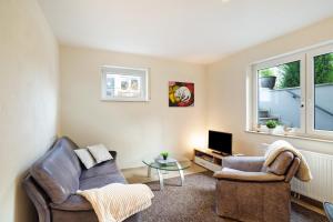 a living room with two chairs and a tv at Ferienwohnung Schwarzwaldperle in Baden-Baden