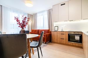 a kitchen and living room with a table and chairs at ApartamentySnu, Bulwary IV z parkingiem in Radom