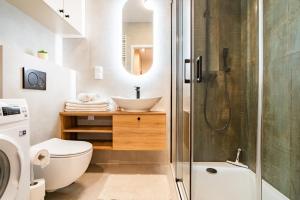 a bathroom with a toilet and a sink and a shower at ApartamentySnu, Bulwary IV z parkingiem in Radom