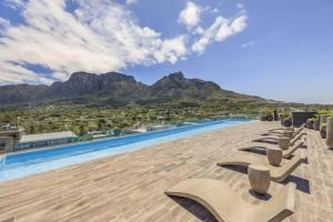 a row of chaise lounges on the roof of a resort at Luxury apartment in Newlands in Cape Town