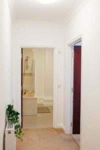 a hallway with a bathroom with a sink and a tub at A 3 bedroom apartment with parking in central Kingsbridge in Kingsbridge