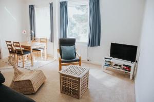 キングスブリッジにあるA 3 bedroom apartment with parking in central Kingsbridgeのリビングルーム(テレビ、テーブル、椅子付)